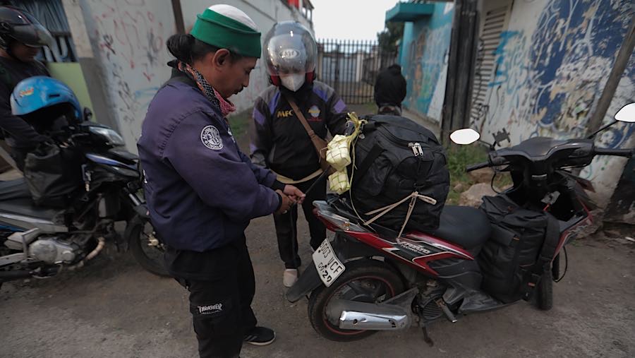Pemudik bersepeda motor merapihkan barang bawaannya di jalan Inspeksi Kalimalang, Jakarta Timur, Kamis (18/3/2026). (Bloomberg Technoz/Andrean K)