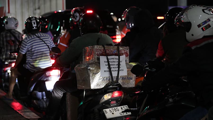 Tulisan unik terlihat pada bagian belakang barang bawaan pemudik. (Bloomberg Technoz/Andrean Kristianto)