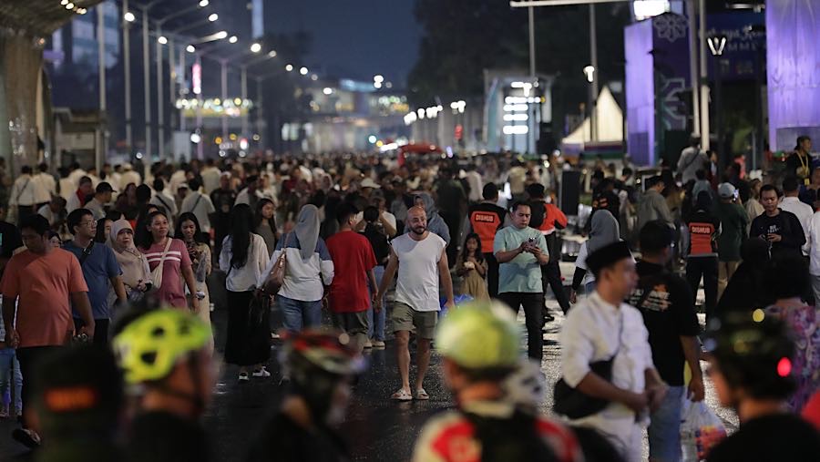 Warga berjalan saat Car Free Night perayaan malam takbir di Bundaran HI, Jakarta, Jumat (20/3/2026. (Bloomberg Technoz/Andrean Kristianto)