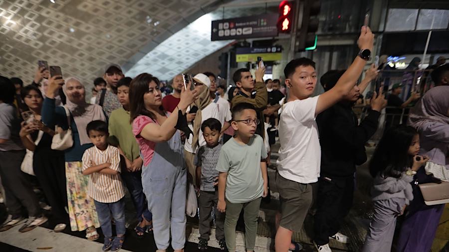 Momen ini menjadi pusat perhatian warga yang berada di kawasan Bundaran HI.  (Bloomberg Technoz/Andrean Kristianto)