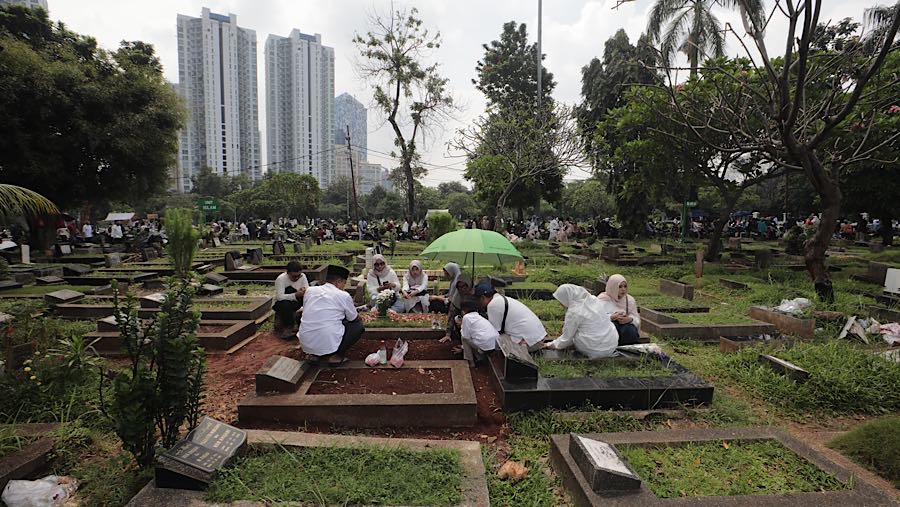 Mereka membersihkan makam serta memanjatkan doa bagi orang-orang tercinta. (Bloomberg Technoz/Andrean Kristianto)