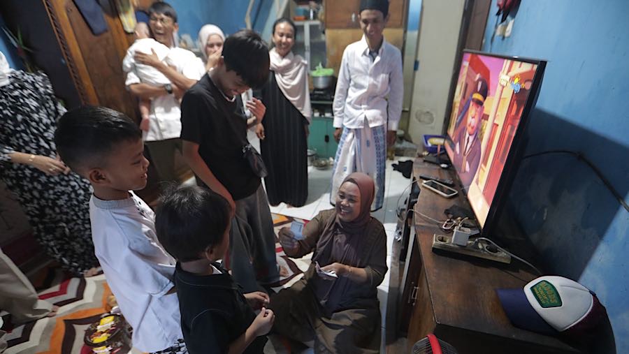 Warga berkeliling dari satu rumah ke rumah lain, sementara anak-anak yang datang turut menerima ‘salam tempel’. (Bloomberg Technoz/Andrean Kristianto)