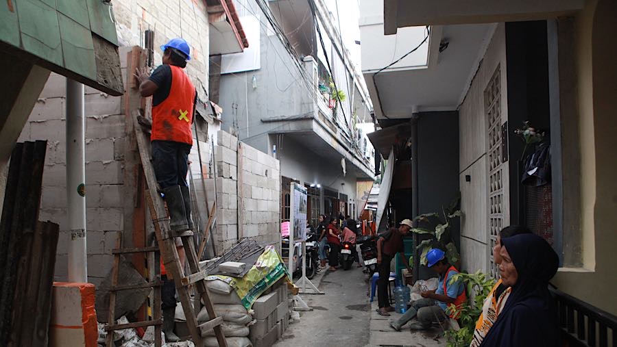 Pekerja merenovasi rumah warga pada program Penataan Kawasan Kumuh di Menteng Tenggulun, Jakarta, Senin (6/4/2026). (Bloomberg Technoz/Andrean K)