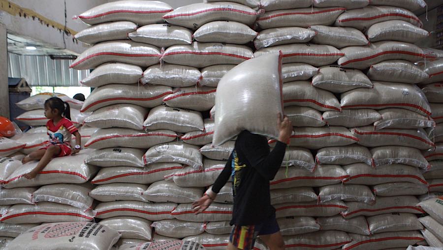 Pekerja memanggul karung beras di salah satu toko di Jakarta Selatan, Selasa (7/4/2026). (Bloomberg Technoz/Andrean Kristianto)