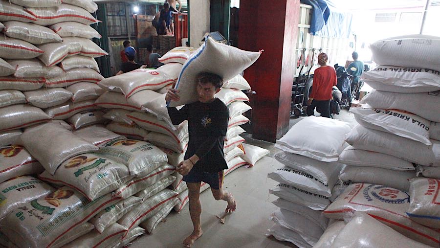 Pekerja memanggul karung beras di salah satu toko di Jakarta Selatan, Selasa (7/4/2026). (Bloomberg Technoz/Andrean Kristianto)