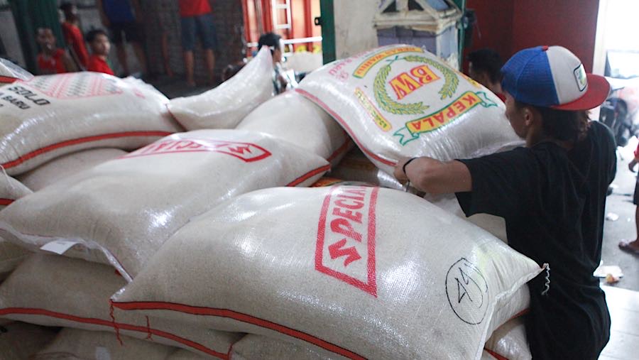 Pekerja merapihkan karung beras di salah satu toko di Jakarta Selatan, Selasa (7/4/2026). (Bloomberg Technoz/Andrean Kristianto)