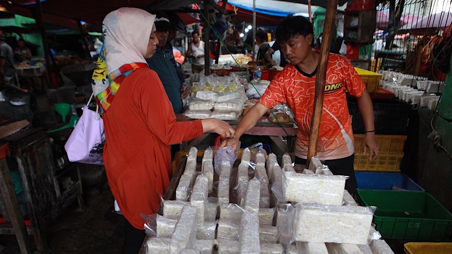 Selain perajin, pedagang tempe di Pasar Minggu juga mengaku telah menaikkan harga jualnya. (Bloomberg Technoz/Andrean Kristianto)