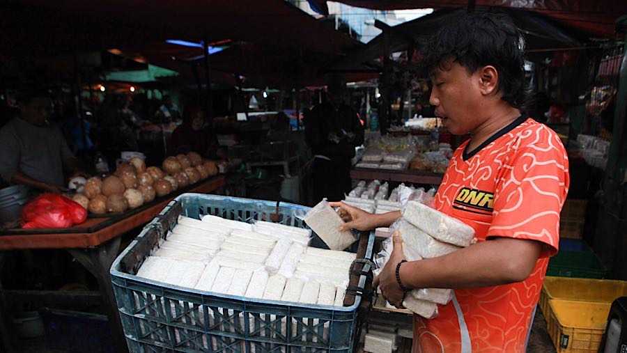 Ipang penjual tempe di Pasar Minggu mengaku menaikkan harga jual tempe sebesar Rp500 hingga Rp1.000. (Bloomberg Technoz/Andrean Kristianto)
