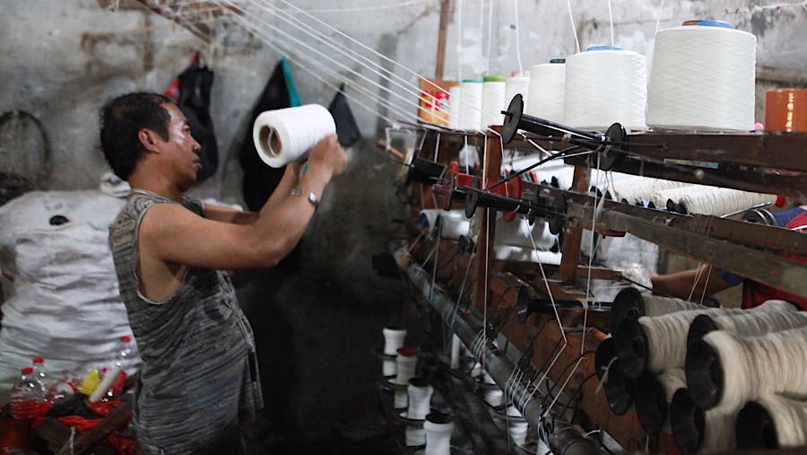 Pekerja memintal benang di Kebayoran Lama, Jakarta, Selasa (14/4/2026). (Bloomberg Technoz/Andrean Kristianto)