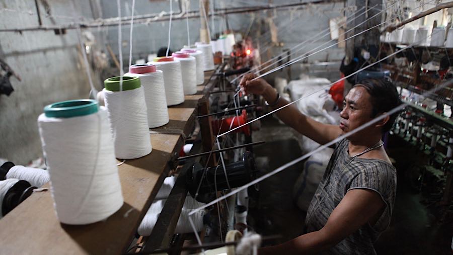 Pekerja memintal benang di Kebayoran Lama, Jakarta, Selasa (14/4/2026). (Bloomberg Technoz/Andrean Kristianto)