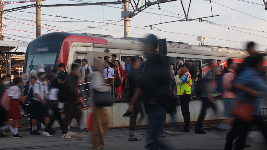 Sejumlah petugas berjaga untuk membantu mengarahkan penumpang yang hendak naik dan turun Commuter Line (KRL). (Bloomberg Technoz/Andrean Kristianto)