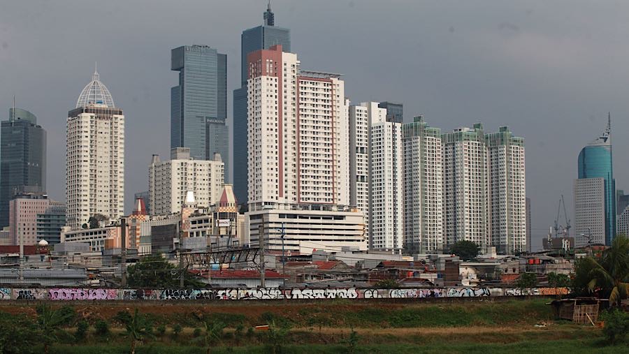 Suasana pemukiman warga berlatar gedung di Jakarta, Kamis (16/4/2026). (Bloomberg Technoz/Andrean Kristianto)