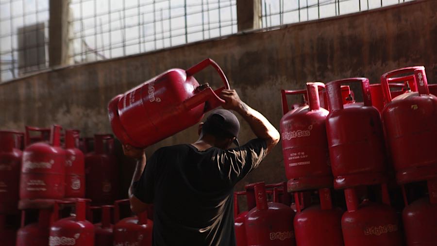 Pekerja membawa tabung gas LPG non subsidi di Pasar Rebo, Jakarta, Senin (20/4/2026). (Bloomberg Technoz/Andrean Kristianto)
