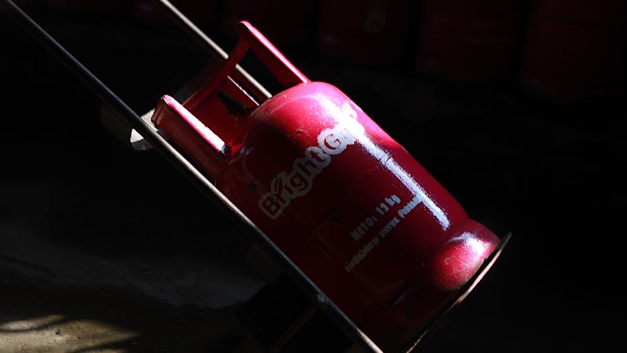 Pekerja membawa tabung gas LPG non subsidi di Pasar Rebo, Jakarta, Senin (20/4/2026). (Bloomberg Technoz/Andrean Kristianto)