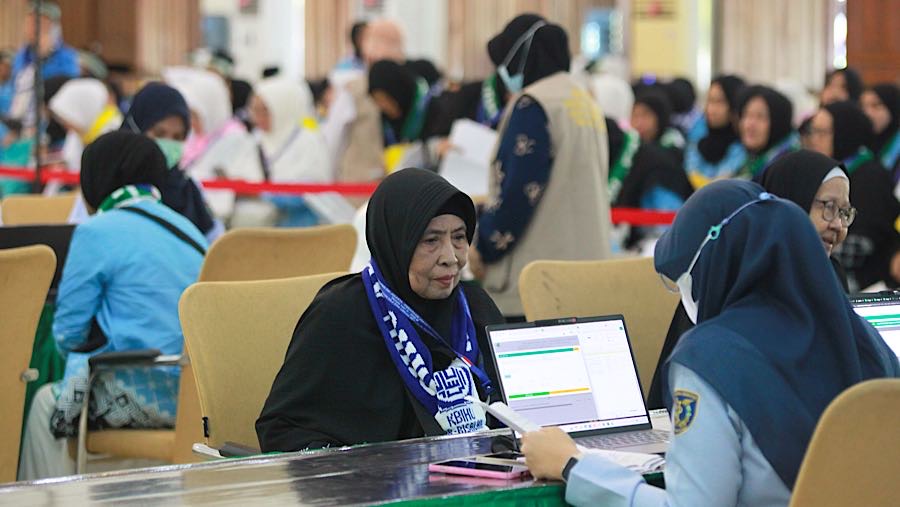 Jamaah haji mengikuti proses sebelum pemberangkatan di Asrama Haji Pondok gede, Jakarta, Selasa (21/4/2026). (Bloomberg Technoz/Andrean Kristianto)