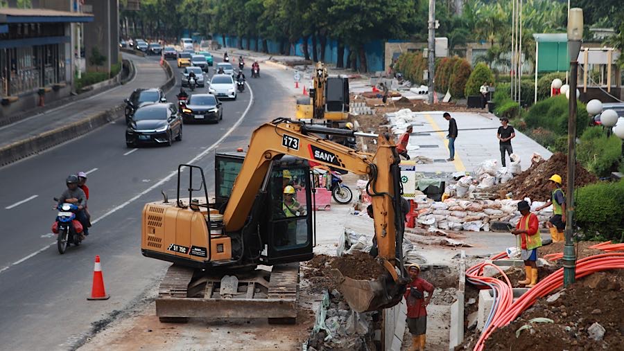 Pekerja menyelesaikan proyek revitalisasi trotoar di Jalan H.R. Rasuna Said, Jakarta, Rabu (22/4/2026). (Bloomberg Technoz/Andrean Kristianto)