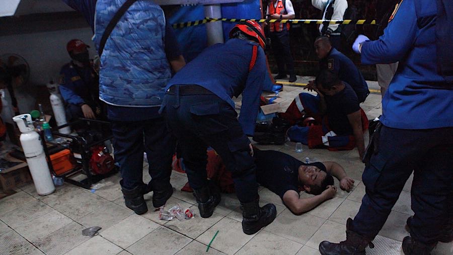 Beberapa petugas terlihat kelelahan usai melakukan evakuasi korban yang terjebak di dalam gerbong. (Bloomberg Technoz/Andrean Kristianto)