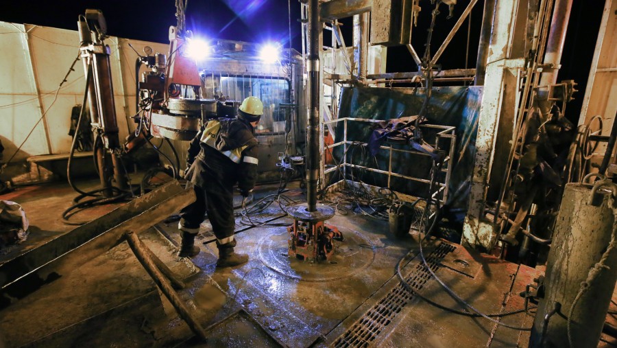 Seorang pekerja mengoperasikan mesin di area meja putar anjungan pengeboran minyak, yang dioperasikan oleh Rosneft PJSC./Bloomberg-Andrey Rudakov