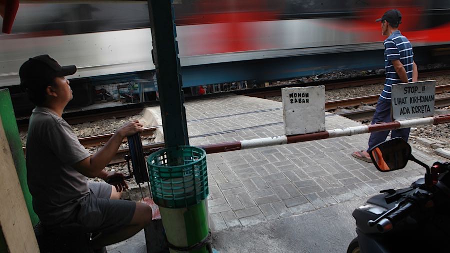 Kendaraan roda dua antre melewati perlintasan kereta api sebidang di Tebet Timur, Jakarta, Kamis (30/4/2026). (Bloomberg Technoz/Andrean Kristianto)
