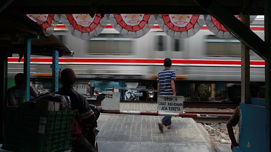 Iwan bergantian dengan rekan-rekannya menjaga perlintasan ini untuk mengurangi tingkat kecelakaan. (Bloomberg Technoz/Andrean Kristianto)