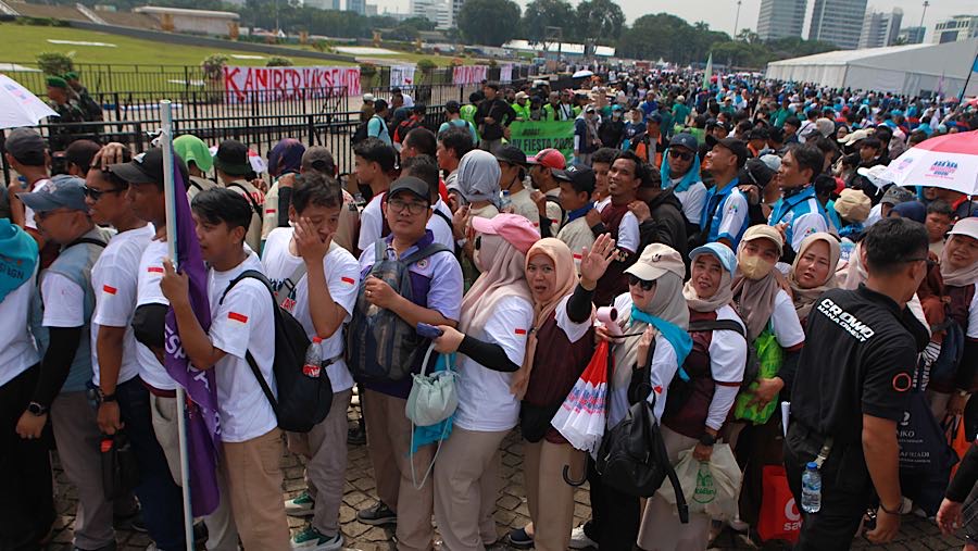 Mereka mengantre di beberapa titik yang membagikan paket sembako secara rapih. (Bloomberg Technoz/Andrean Kristianto)