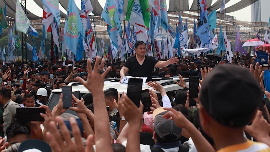 Usai memberikan sambutan, Presiden Prabowo meninggalkan lokasi sambil membagikan kaos dari atas mobilnya. (Bloomberg Technoz/Andrean K)