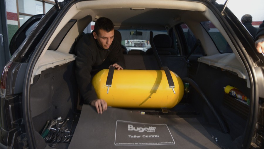Teknisi menempatkan tangki gas alam di bagasi Bugatti untuk mengubahnya menjadi unit bahan bakar ganda yang beroperasi dengan CNG./Bloomberg