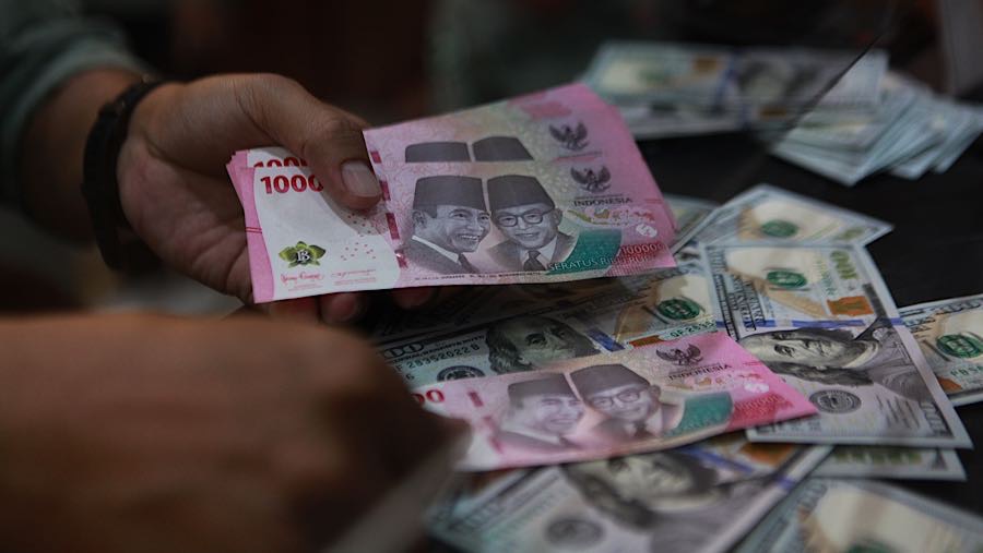 Karyawan menghitung mata uang rupiah di tempat penukaran mata uang, Jakarta, Selasa (12/5/2026). (Bloomberg Technoz/Andrean Kristianto)