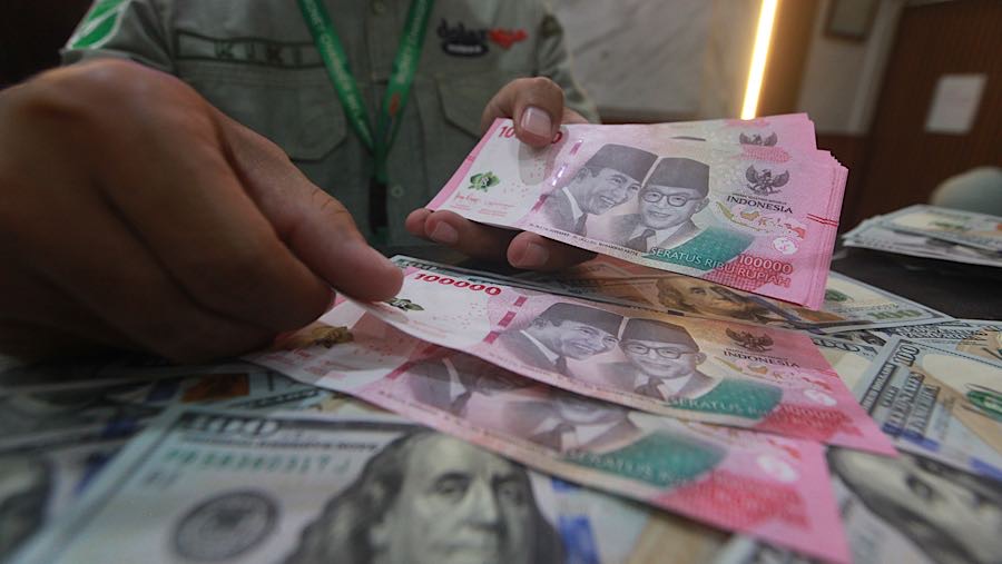 Karyawan menghitung mata uang rupiah di tempat penukaran mata uang, Jakarta, Selasa (12/5/2026). (Bloomberg Technoz/Andrean Kristianto)