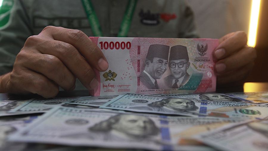 Karyawan menghitung mata uang rupiah di tempat penukaran mata uang, Jakarta, Selasa (12/5/2026). (Bloomberg Technoz/Andrean Kristianto)