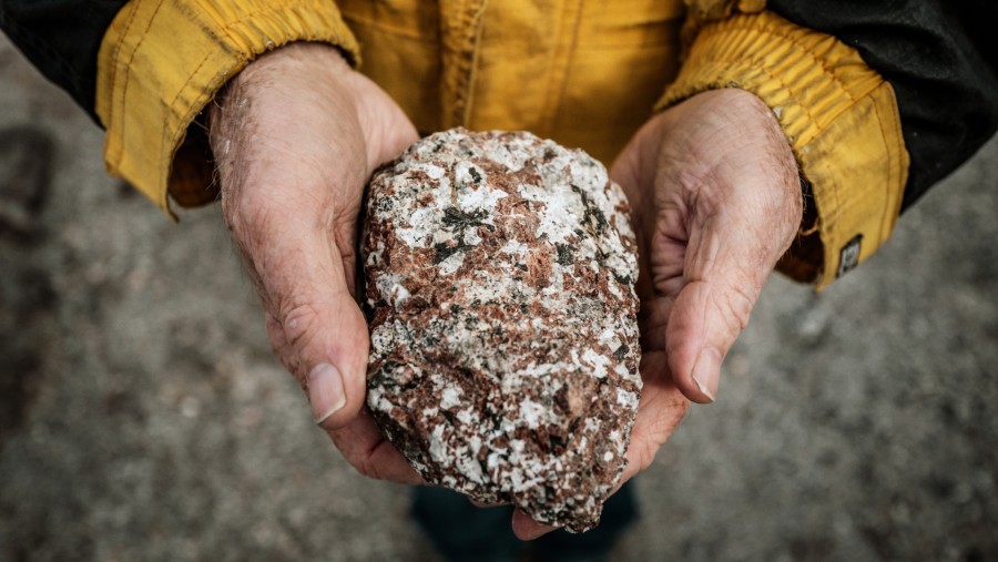 Geolog Greg Barnes, mantan pemilik lokasi mineral tanah jarang Tanbreez, memegang sebuah batu yang mengandung kristal di lokasi penambangan./Bloomberg