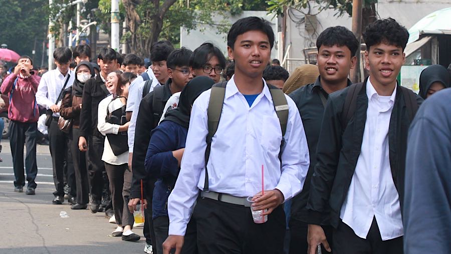 Sejumlah pelamar datang lebih awal dengan harapan mendapat kesempatan bekerja di mini market Family Mart. (Bloomberg Technoz/Andrean Kristianto)