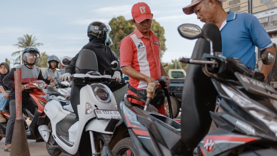 Seorang pekerja mengisi bahan bakar sepeda motor di SPBU PT Pertamina di Bengkulu, Indonesia./Bloomberg-Muhammad Fadli