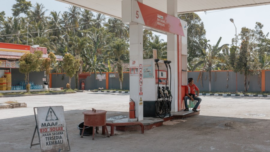 Seorang pekerja duduk di dekat pompa bahan bakar di sebuah SPBU PT Pertamina di Bihar, Provinsi Lampung./Bloomberg-Muhammad Fadli