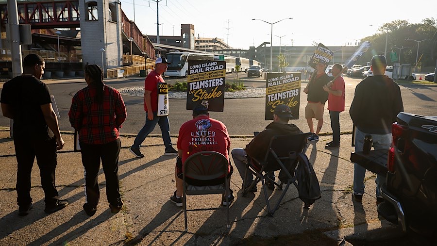 Pekerja melakukan aksi mogok di dekat bus antar-jemput di stasiun LIRR Huntington, New York, AS, Senin (18/5/2026). (Michael Nagle/Bloomberg)