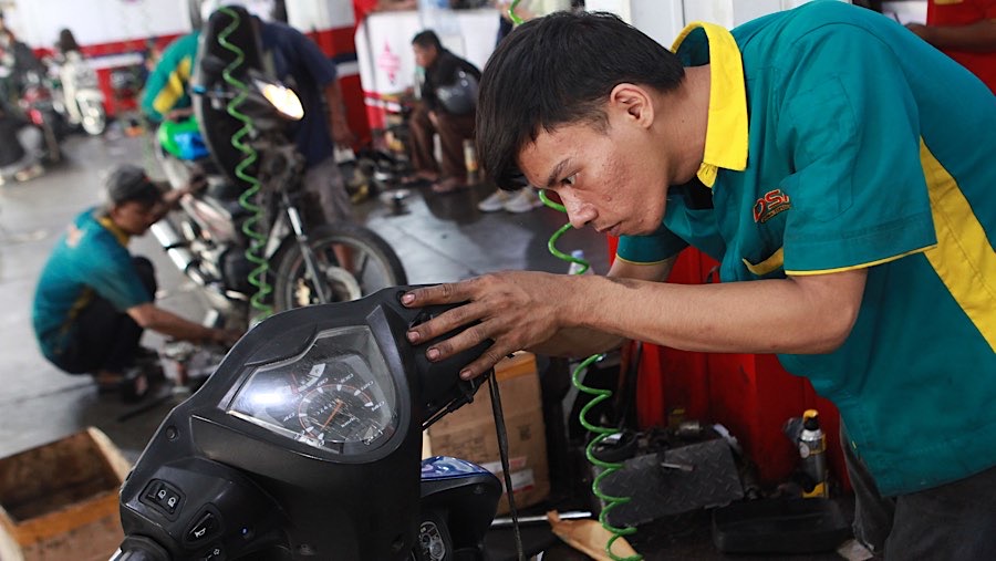Mekanik memperbaiki sepeda motor di salah satu bengkel di Pasar Minggu, Jakarta, Senin (25/6/2026). (Bloomberg Technoz/Andrean Kristianto)