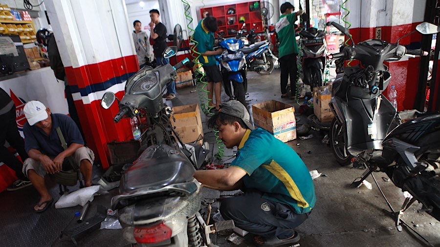 Mekanik memperbaiki sepeda motor di salah satu bengkel di Pasar Minggu, Jakarta, Senin (25/6/2026). (Bloomberg Technoz/Andrean Kristianto)