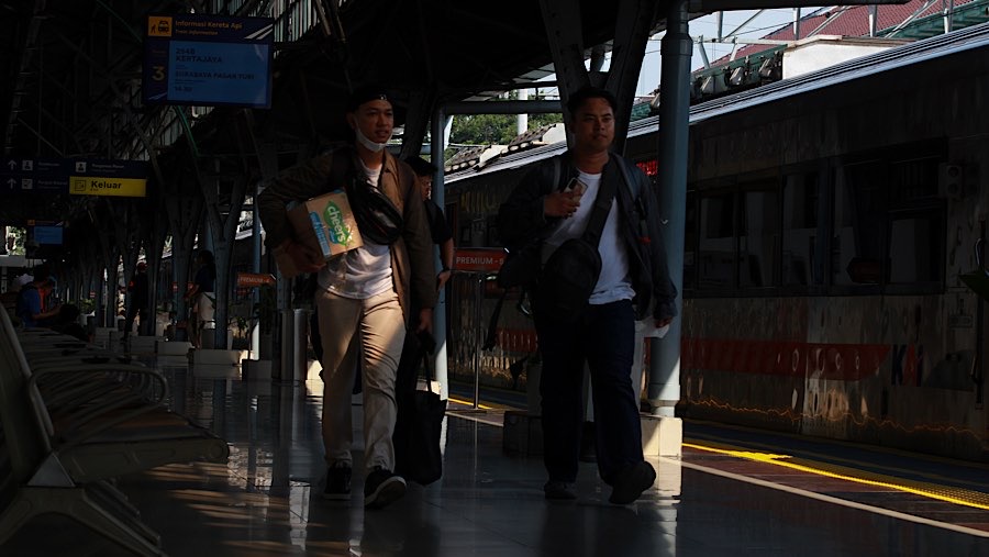 Calon penumpang berjalan menuju gerbong kereta api jarak jauh di Stasiun Pasar Senen, Selasa (26/5/2026). (Bloomberg Technoz/Andrean Kristianto)