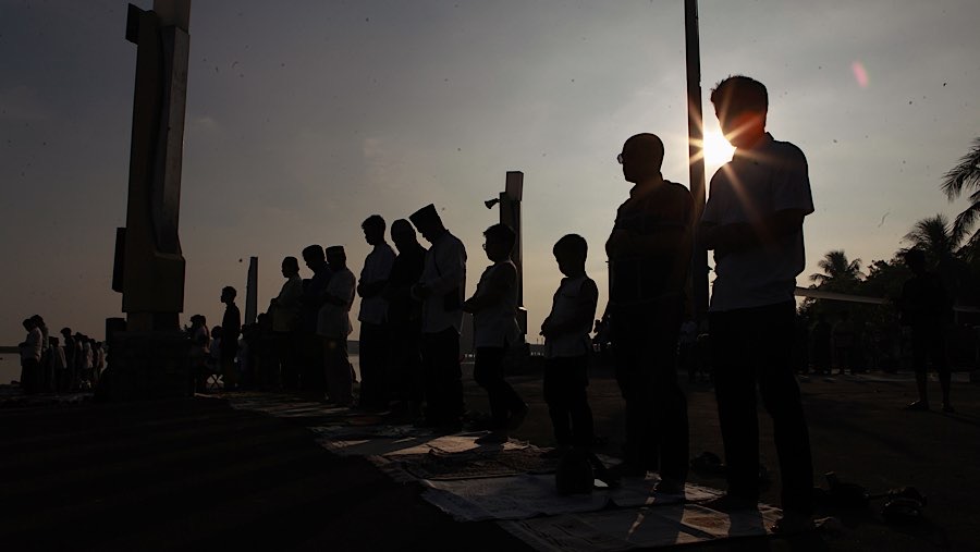 Sajadah serta tikar tampak terbentang di sepanjang area salat yang menghadap langsung ke pantai. (Bloomberg Technoz/Andrean Kristianto)