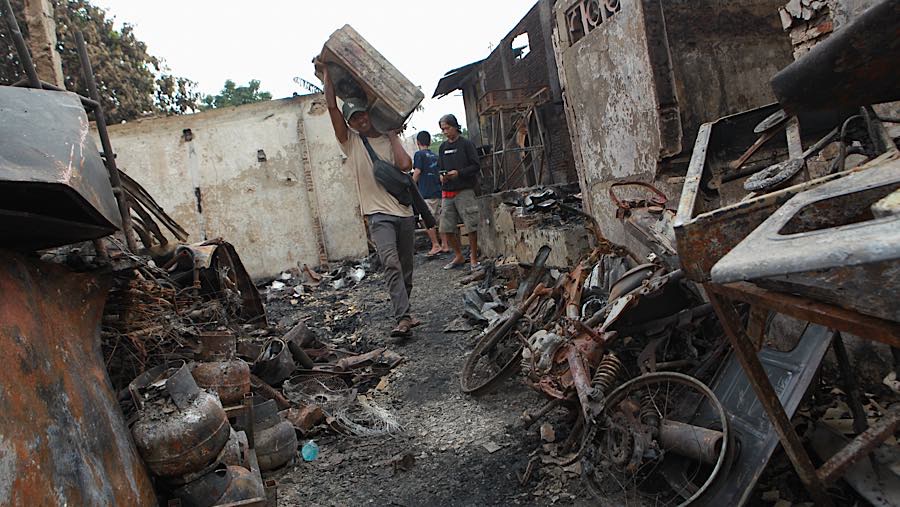 Seseorang mengakut barang di lokasi kebakaran permukiman penduduk di Kebon Kosong, Kemayoran, Jakarta, Selasa (2/6/2026). (Bloomberg Technoz/Andrean)