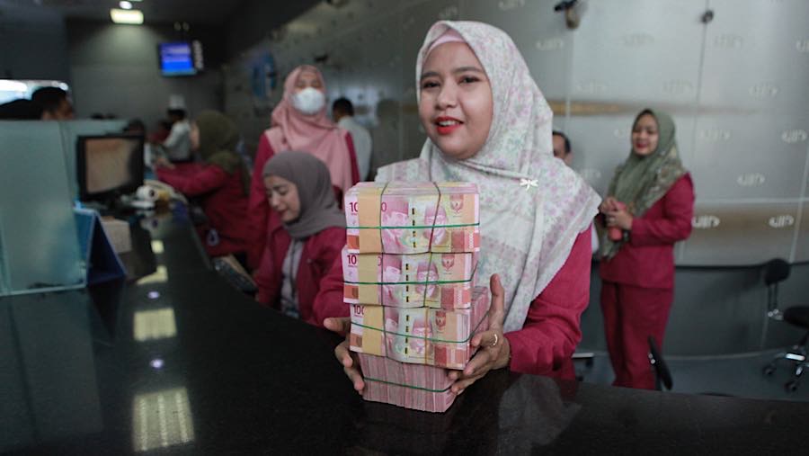 Karyawan membawa mata uang rupiah di salah satu tempat penukaran mata uang di Jakarta, Kamis (4/6/2026). (Bloomberg Technoz/Andrean Kristianto)