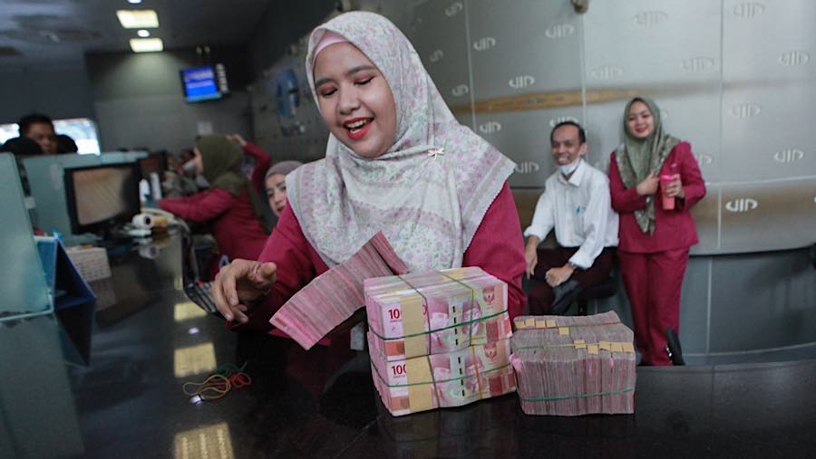 Karyawan membawa mata uang rupiah di salah satu tempat penukaran mata uang di Jakarta, Kamis (4/6/2026). (Bloomberg Technoz/Andrean Kristianto)