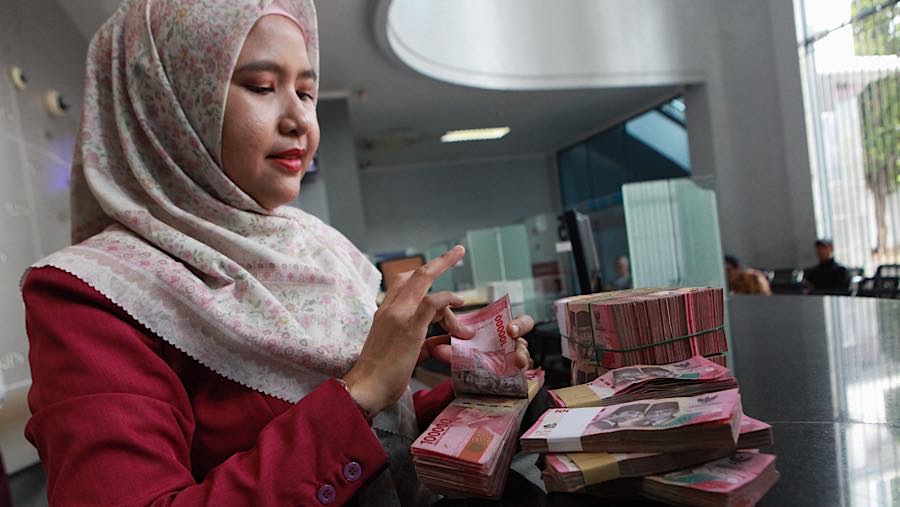 Karyawan menghitung uang rupiah di salah satu tempat penukaran mata uang di Jakarta, Kamis (4/6/2026). (Bloomberg Technoz/Andrean Kristianto)