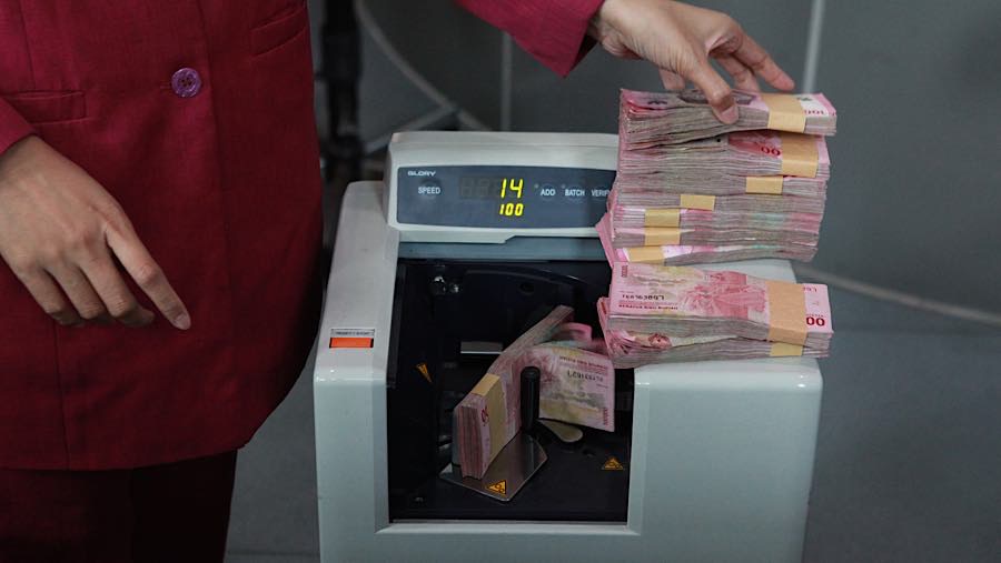 Karyawan menghitung uang rupiah di salah satu tempat penukaran mata uang di Jakarta, Kamis (4/6/2026). (Bloomberg Technoz/Andrean Kristianto)