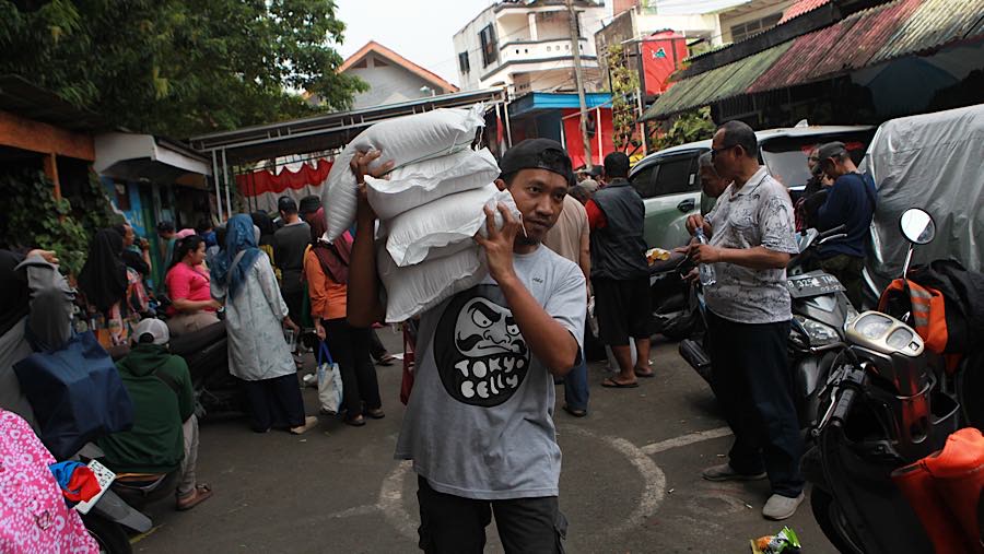 Warga memanggul beras bantuan pangan di wilayah Menteng, Jakarta, Rabu (10/6/2026). (Bloomberg Technoz/Andrean Kristianto)