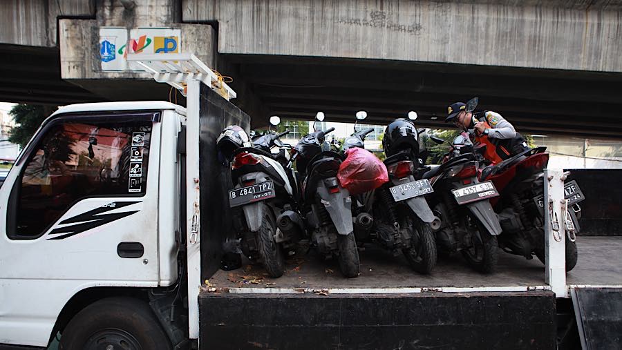 Belasan sepesa motor di kawasan K.H. Mas Mansyur, Jakarta Pusat, terlihat diangkut ke atas truk. (Bloomberg Technoz/Andrean K)