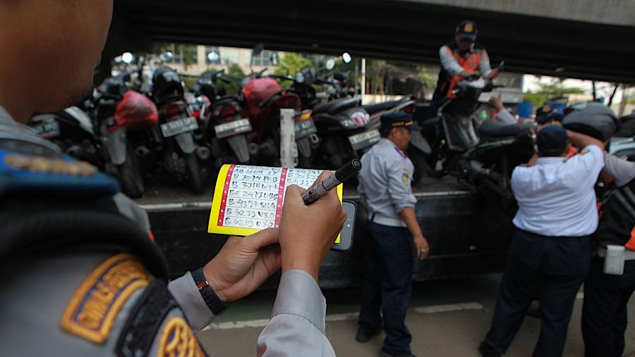Sejumlah personil gabungan melakukan penertiban parkir liar untuk mengembalikan fungsi jalan. (Bloomberg Technoz/Andrean K)