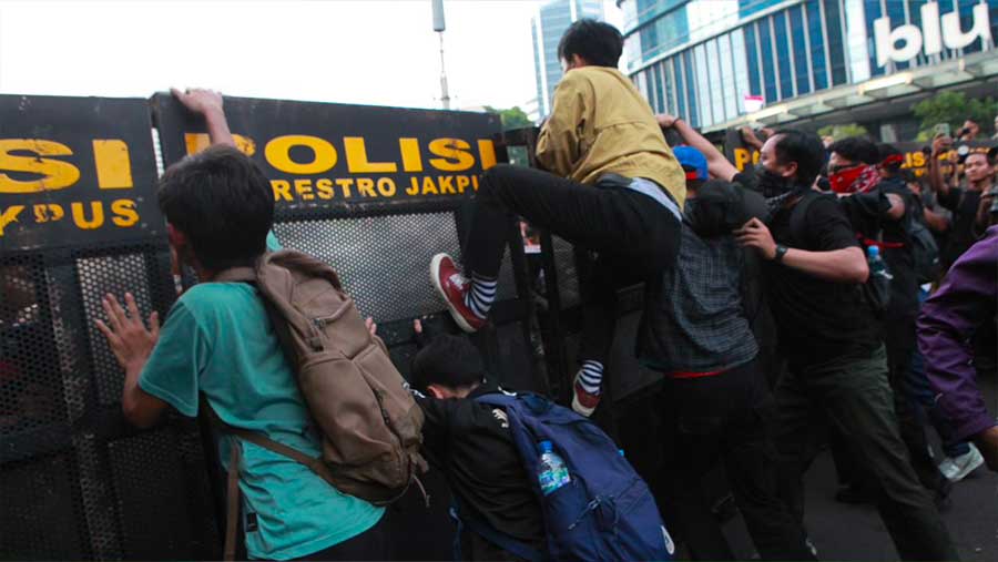 Sejumlah massa mencoba menerobos barikade polisi saat demo di kawasan Dukuh Atas, Jumat (12/6/2026). (Bloomberg Technoz/Andrean Kristianto)
