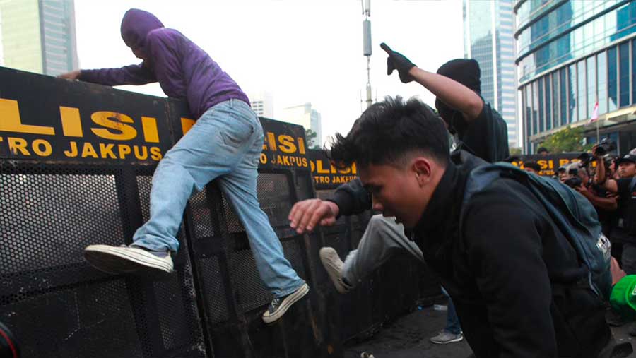 Sejumlah massa mencoba menerobos barikade polisi saat demo di kawasan Dukuh Atas, Jumat (12/6/2026). (Bloomberg Technoz/Andrean Kristianto)
