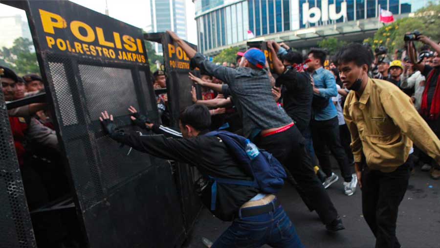Sejumlah massa mencoba menerobos barikade polisi saat demo di kawasan Dukuh Atas, Jumat (12/6/2026). (Bloomberg Technoz/Andrean Kristianto)